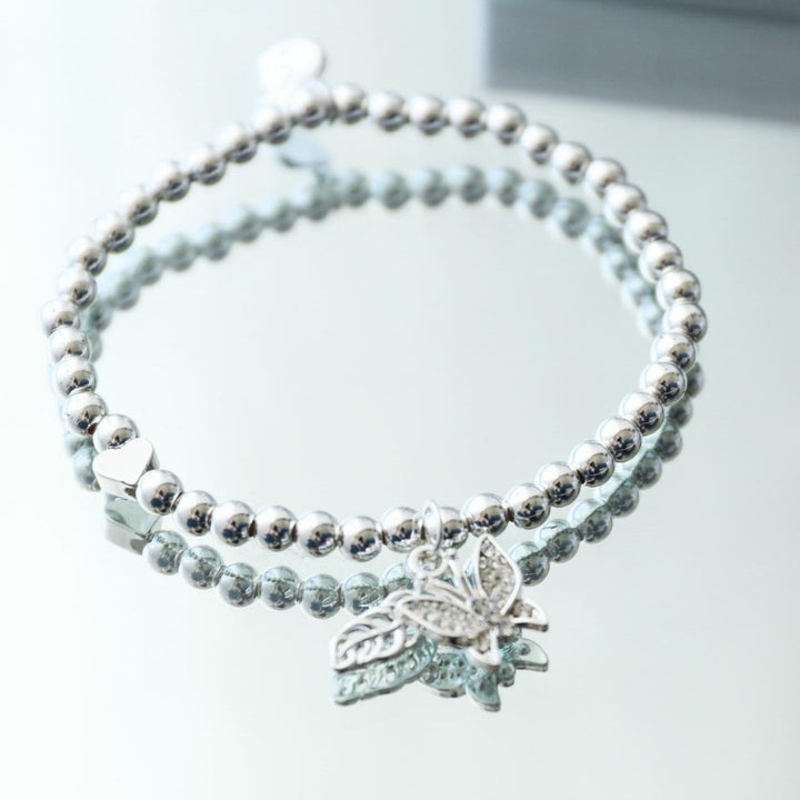 Silver bracelet with a butterfly charm on a white background