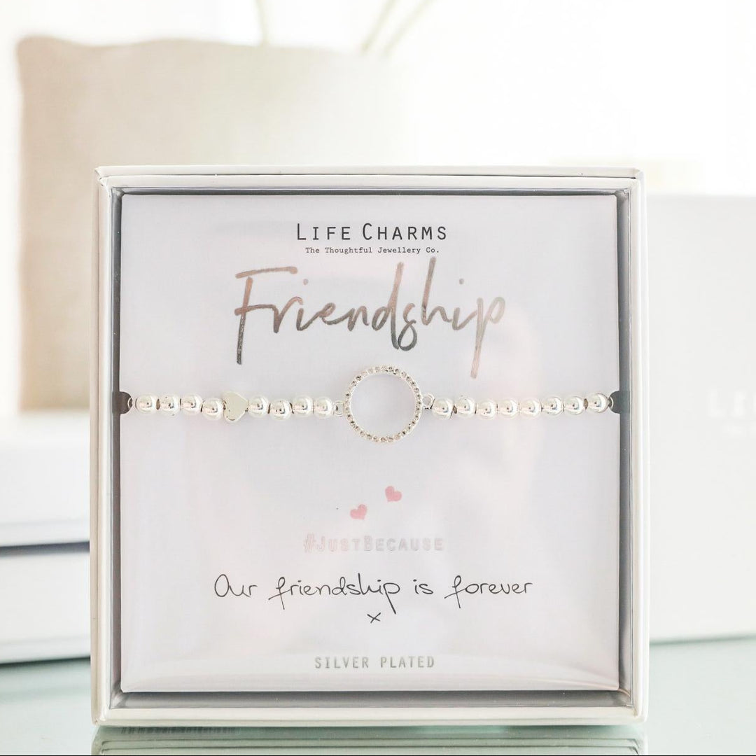 Bracelet in a 'Life Charms' packaging with flowers in the background