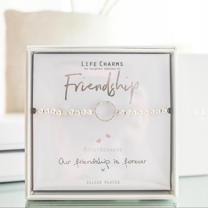 Bracelet in a 'Life Charms' packaging with flowers in the background