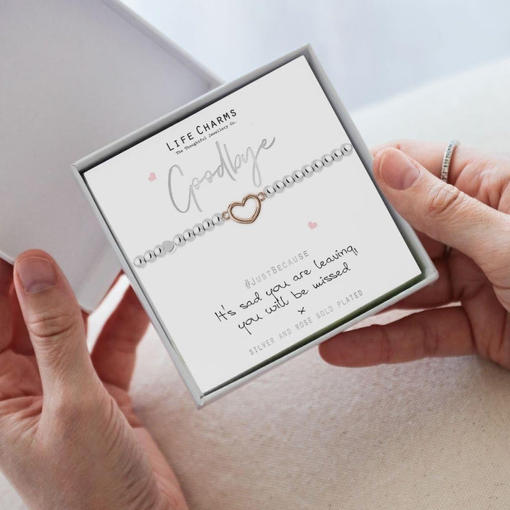 Bracelet with heart charm in a 'Life Charms' box held by hands on a light background