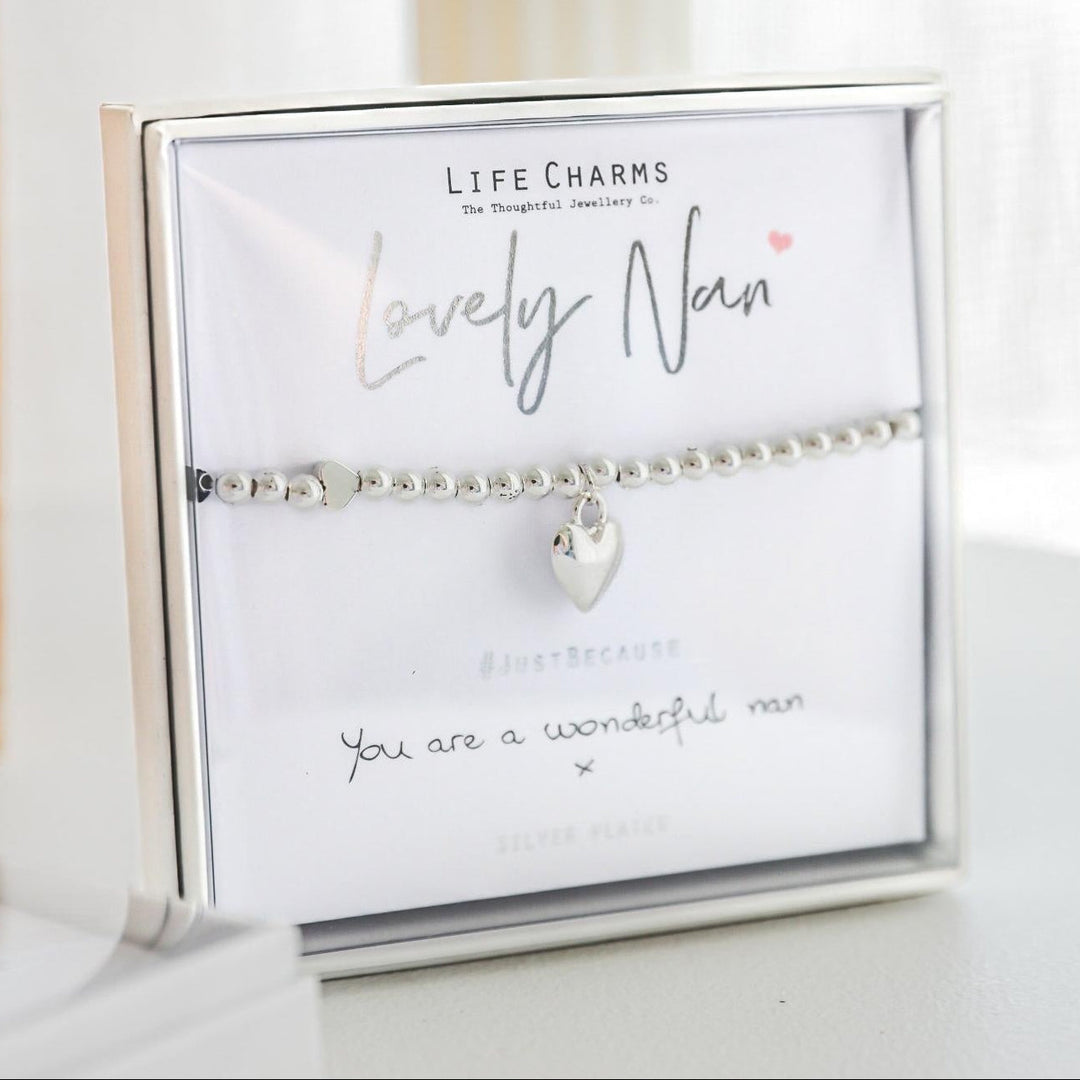 Silver bracelet with heart charm on a branded card