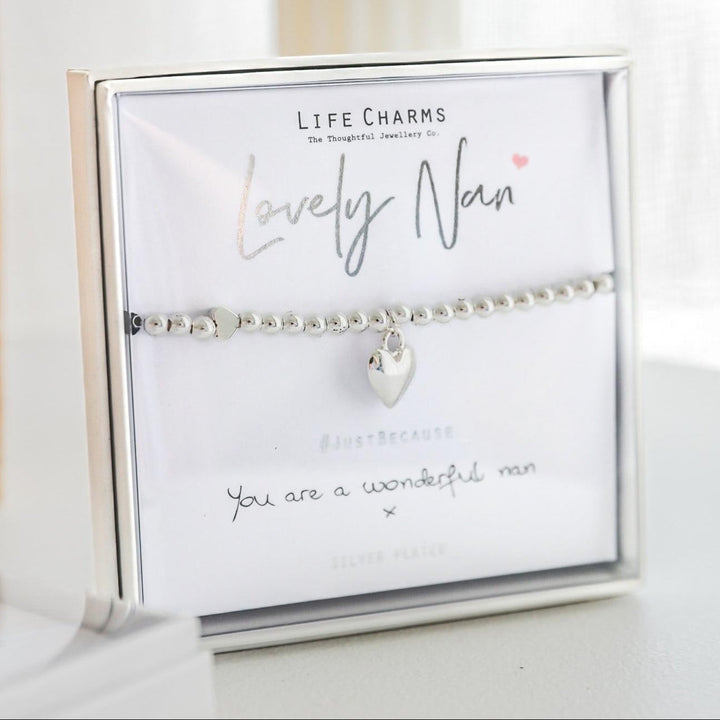 Silver bracelet with heart charm on a branded card