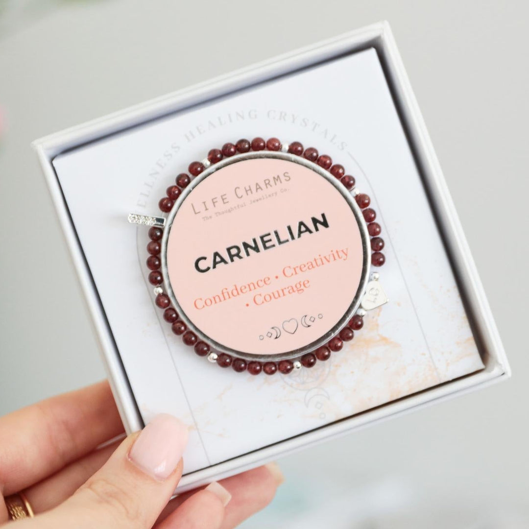 Carnelian bracelet in a box held by a hand with a blurred background