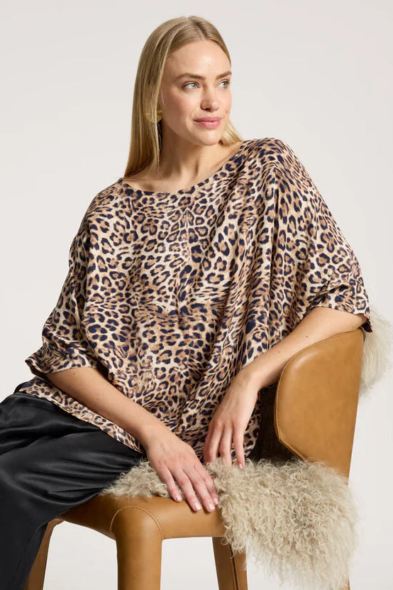 woman on a seat with a leopard print one size top on