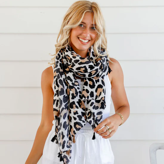 Woman wearing a leopard print scarf against a white background