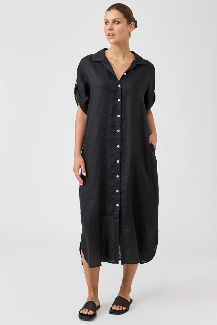 Woman wearing a black button-up dress on a white background