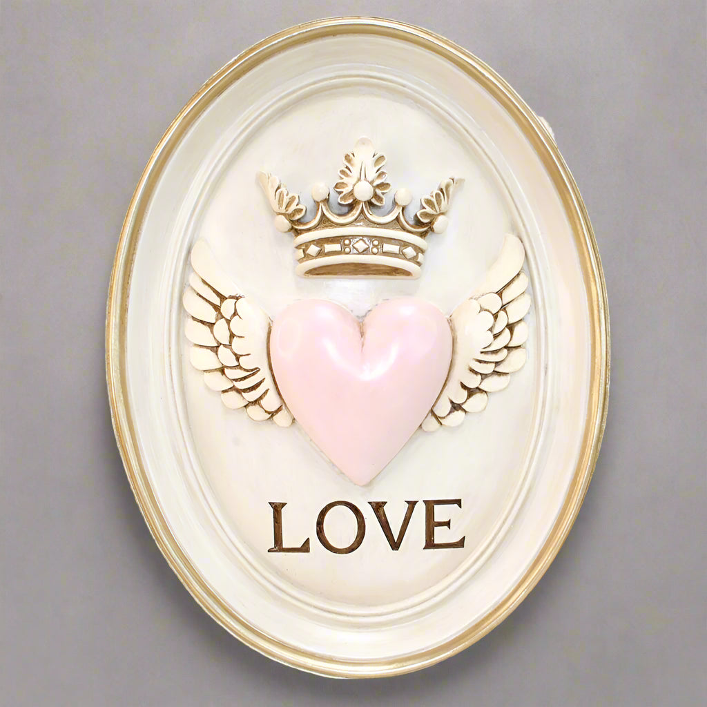 Decorative wall art with a pink heart, wings, and the word 'LOVE' on a white background.