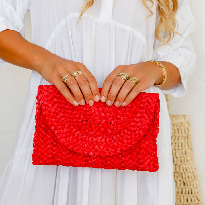 Person holding a red clutch with a white background