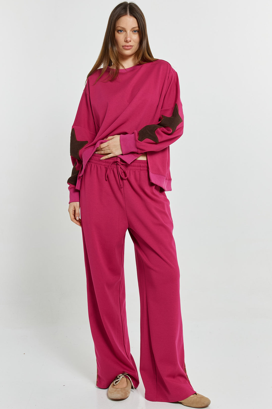 Woman wearing a pink outfit with black accents on a white background