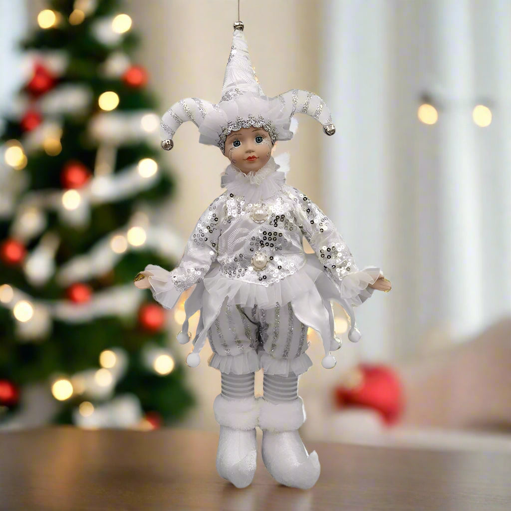Decorative figure in a jester costume with white and silver details on a white background