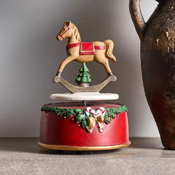 Decorative rocking horse music box on a surface with a neutral background
