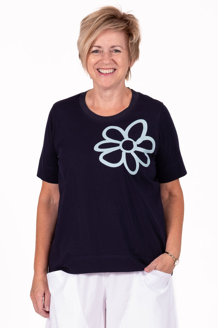 Person wearing a black t-shirt with a white logo and white pants on a white background