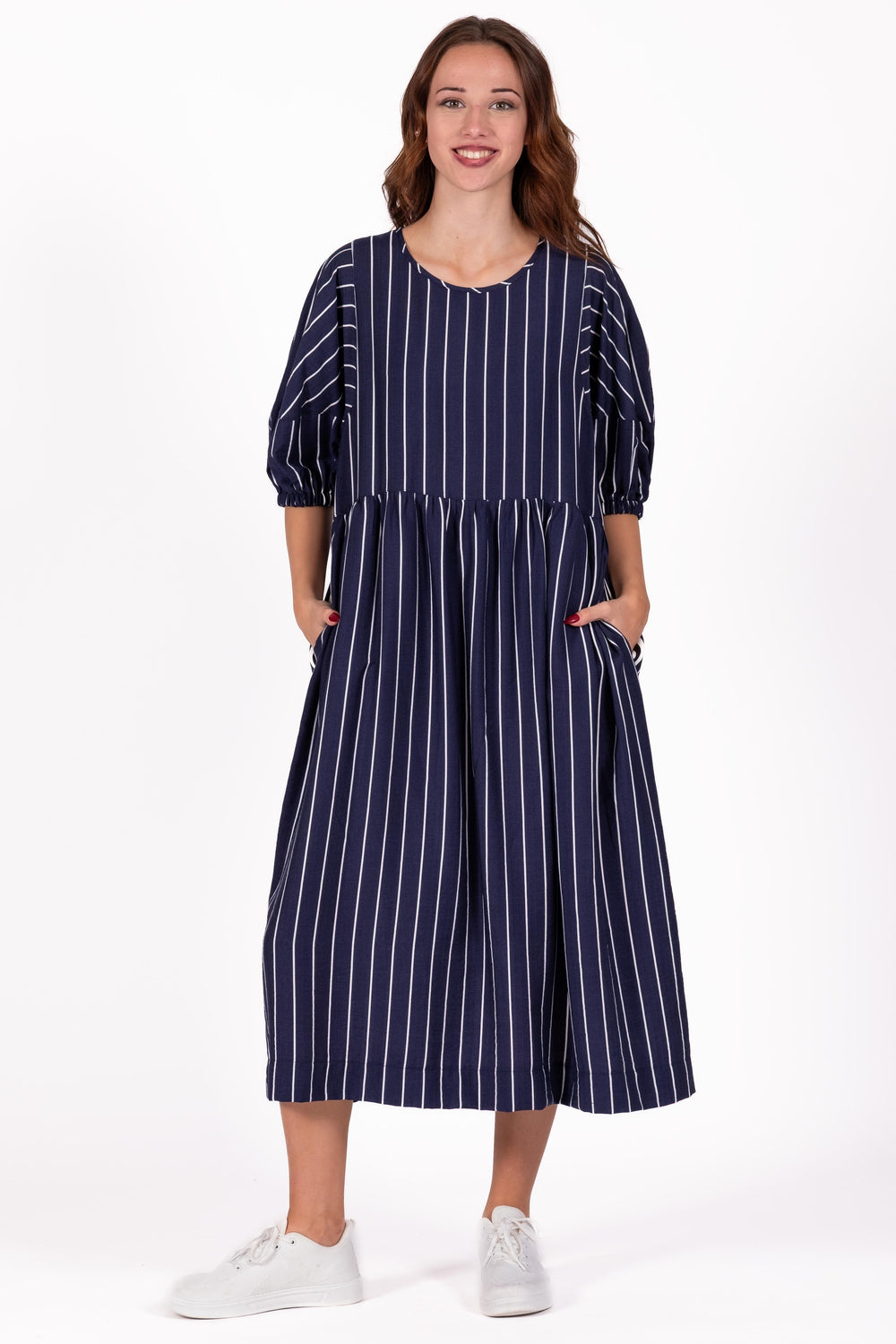 Woman wearing a navy blue and white striped dress on a white background