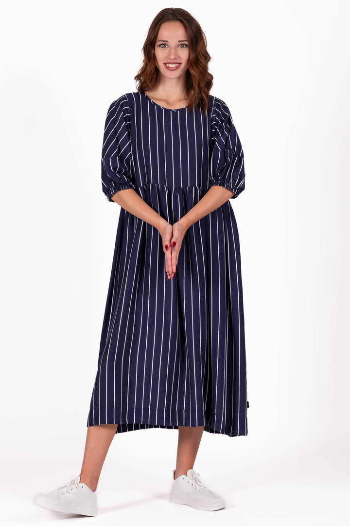 Woman wearing a navy blue striped dress on a white background