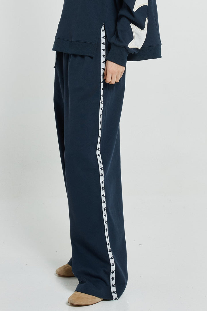 Navy tracksuit with white star design on a white background