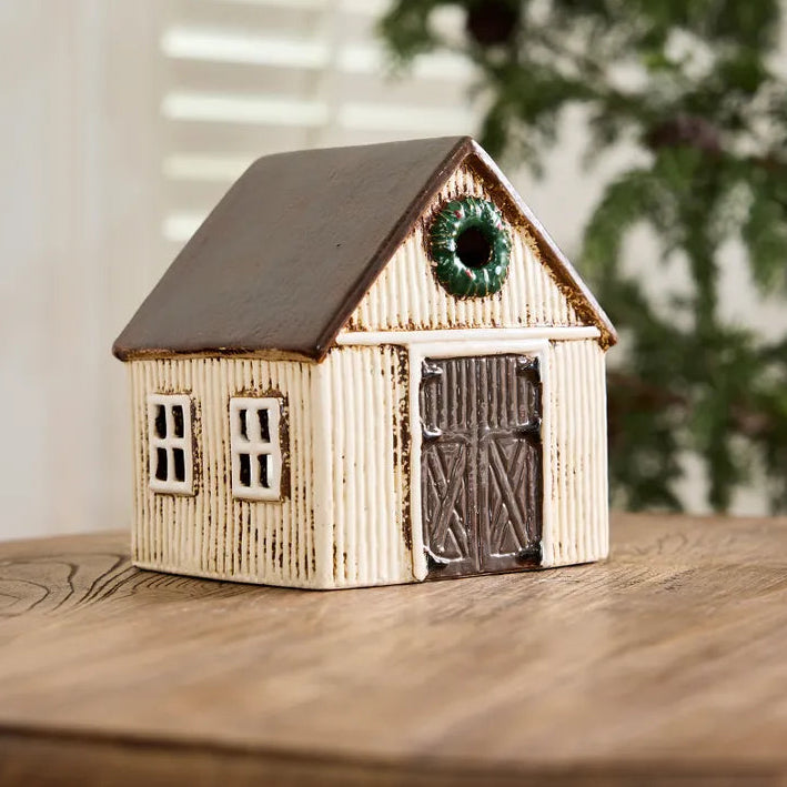 Small wooden house model with a wreath on a wooden surface