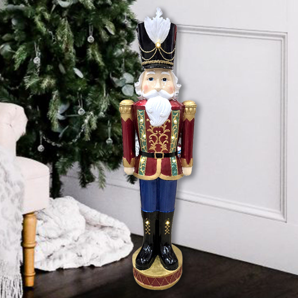 1m tall Decorative nutcracker christmas decoration standing in front of a Christmas tree