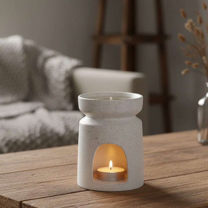 Speckled beige ceramic oil burner on a white background