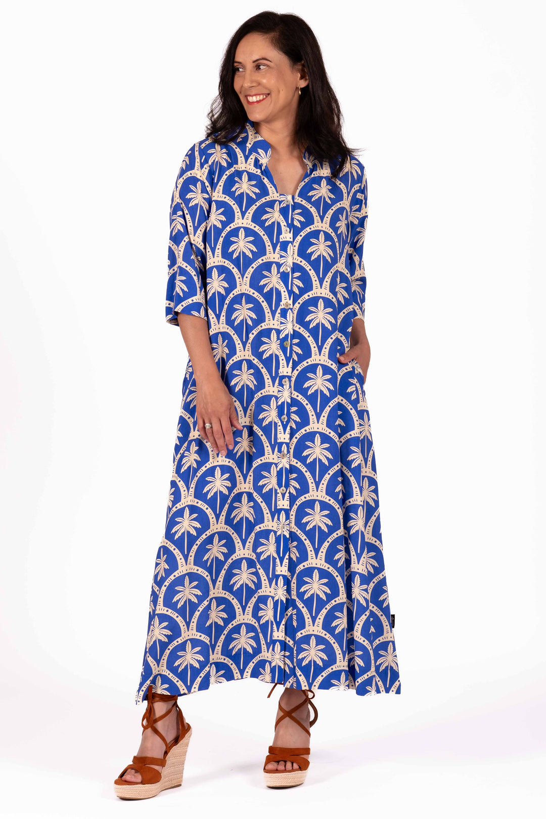 Woman wearing a blue patterned dress on a white background