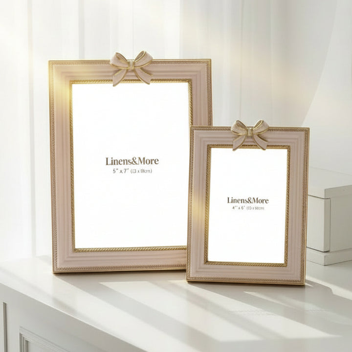 Two decorative picture frames with ribbons on a white background, branded 'Linens & More'.