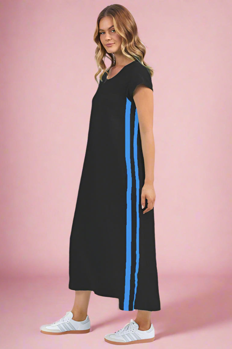 A model wearing a black knee-length dress with blue side taping, paired with white sneakers.