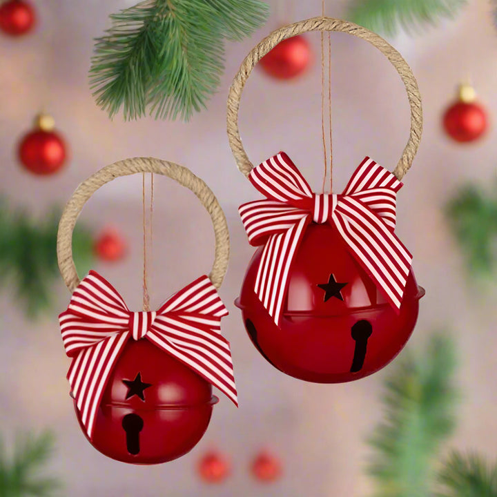 Two red bells with striped bows on a white background