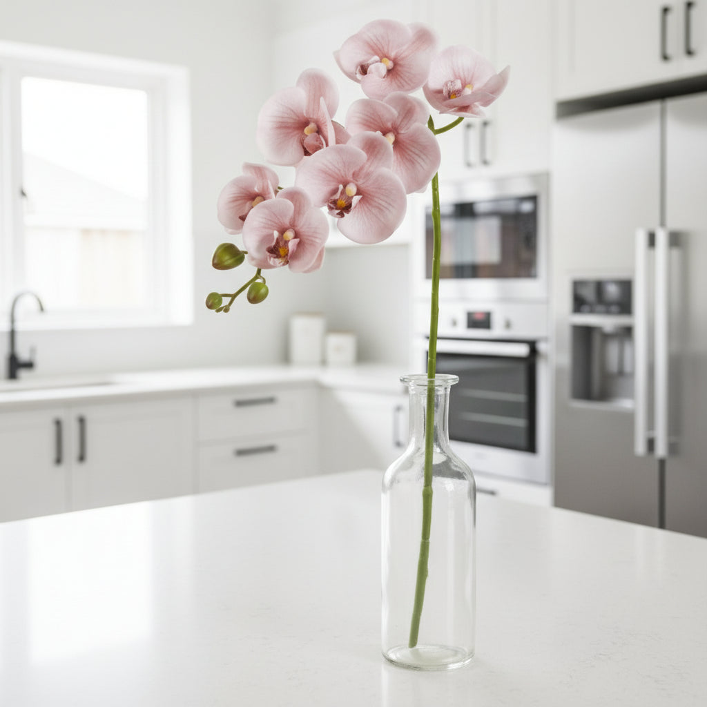 Artificial pink orchid flower stem on a white background