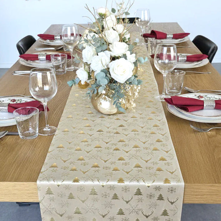Decorative table setting with a patterned table runner, flowers, and cutlery on a wooden table.