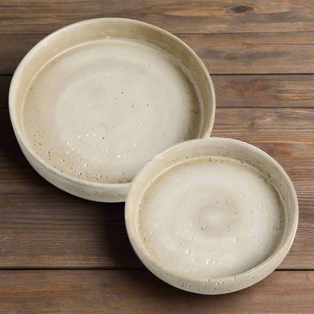 Two beige ceramic bowls on a white background