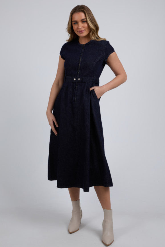 Woman wearing a navy dress on a white background