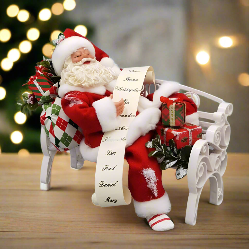 Decorative figure of Santa Claus with a sleigh and presents on a white background