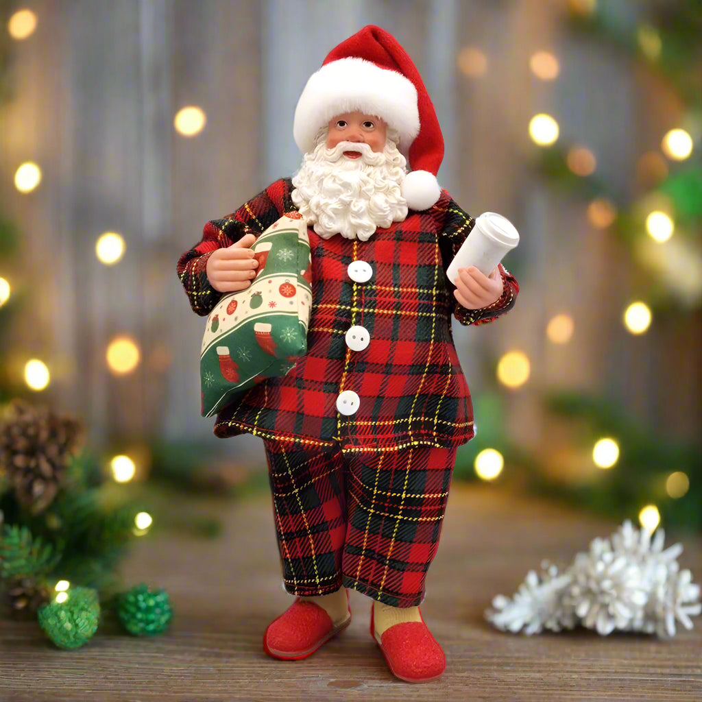 Santa Claus figurine in a plaid suit holding a sack and a scroll on a white background