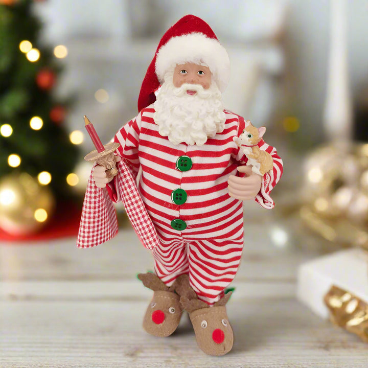 Santa Claus figurine in a red and white striped outfit with a checkered bag and reindeer shoes on a white background.