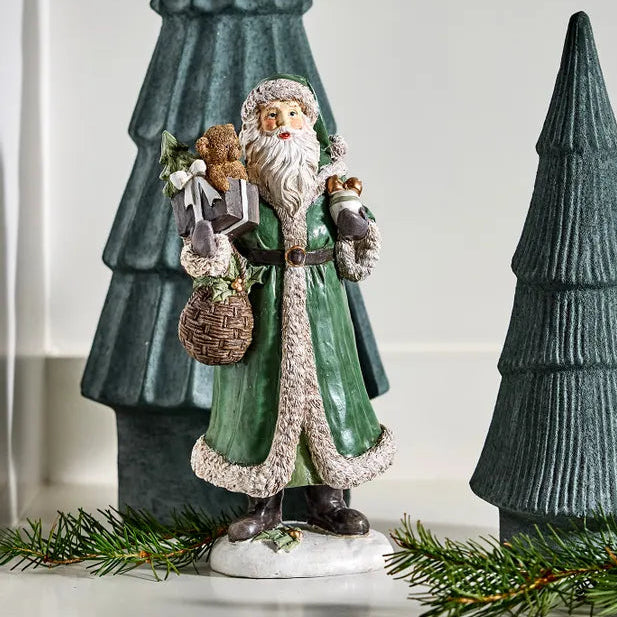 Decorative figure of a Santa Claus with green trees on a white background