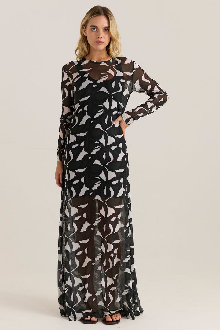 Woman wearing a long black and white patterned sass tarni mesh dress on a white background