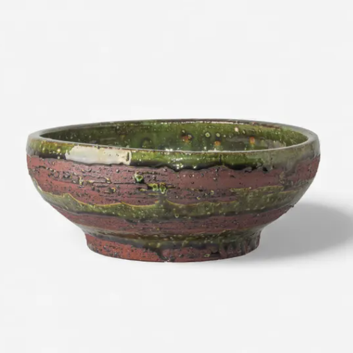 Ceramic bowl with green and brown glaze on a white background