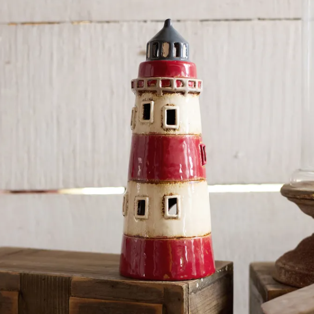 Decorative lighthouse on a wooden surface with a neutral background