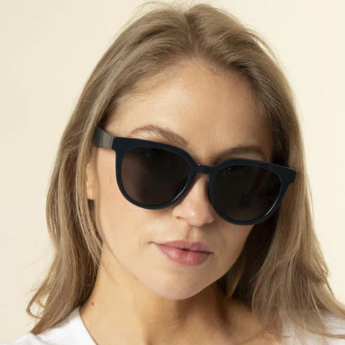 Woman wearing black sunglasses with a plain background