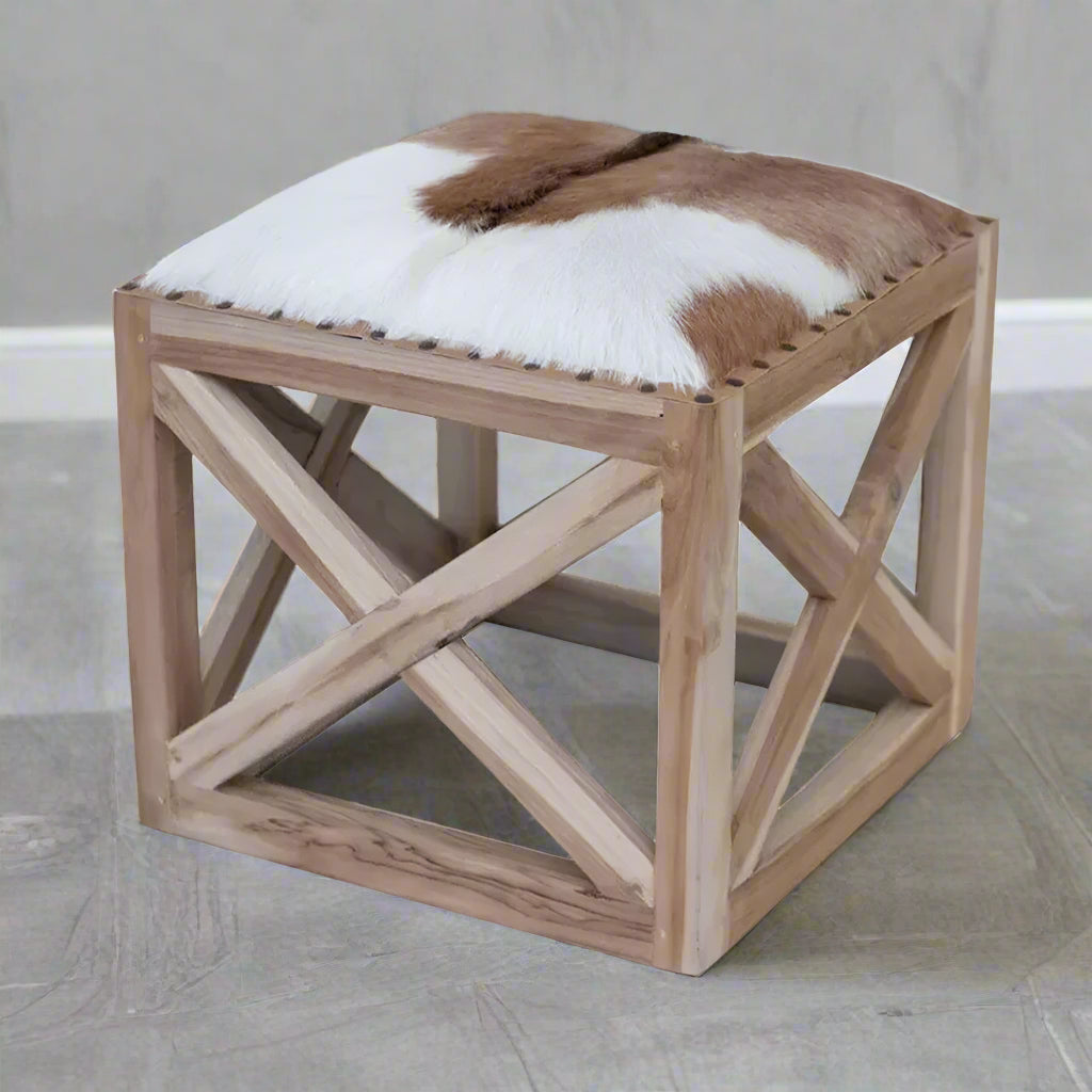 Wooden stool with a cowhide cushion on a white background
