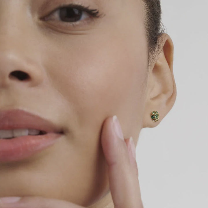 Close-up of a woman wearing a green gemstone ted baker earring with a neutral background