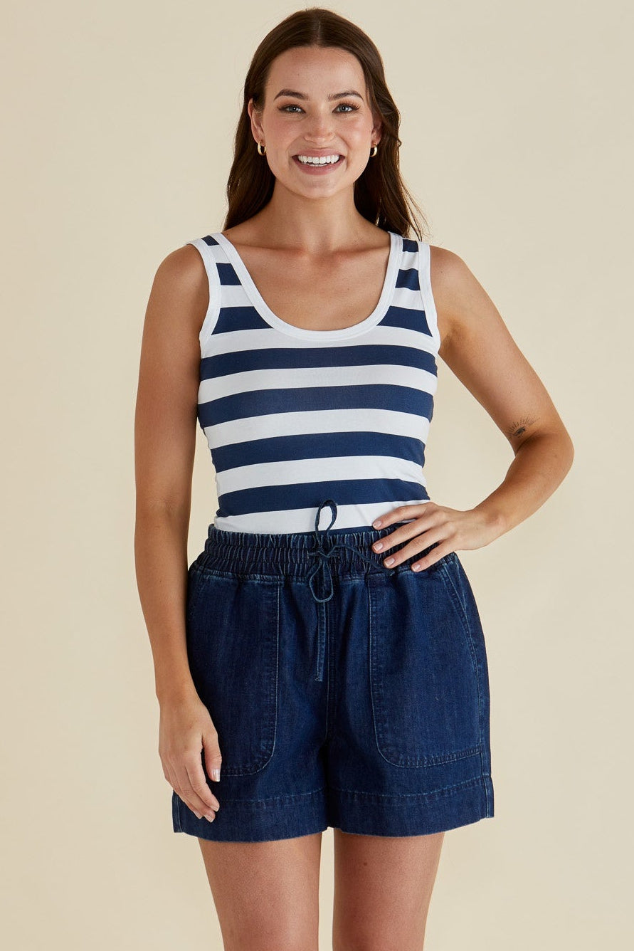 Woman wearing a striped tank top and BETTY BASICS DENIM shorts against a beige background