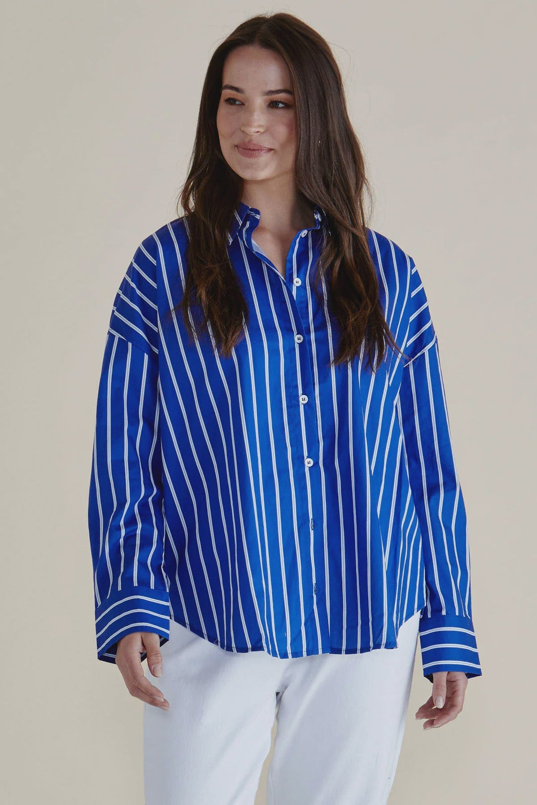 Woman wearing a blue and white striped shirt against a plain background