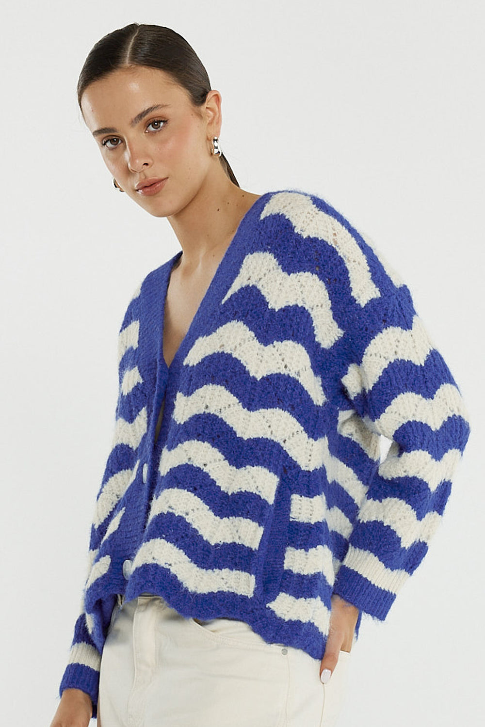 Woman wearing a blue and white striped sweater on a plain background