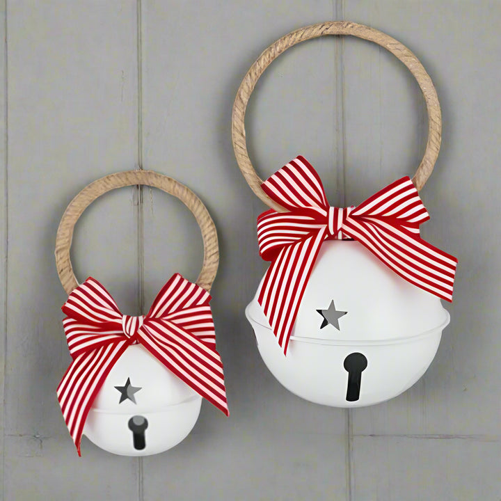 Two white bells with red striped bows on a white background
