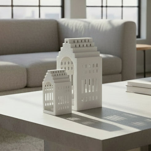 Two white building-shaped candle holders on a white background