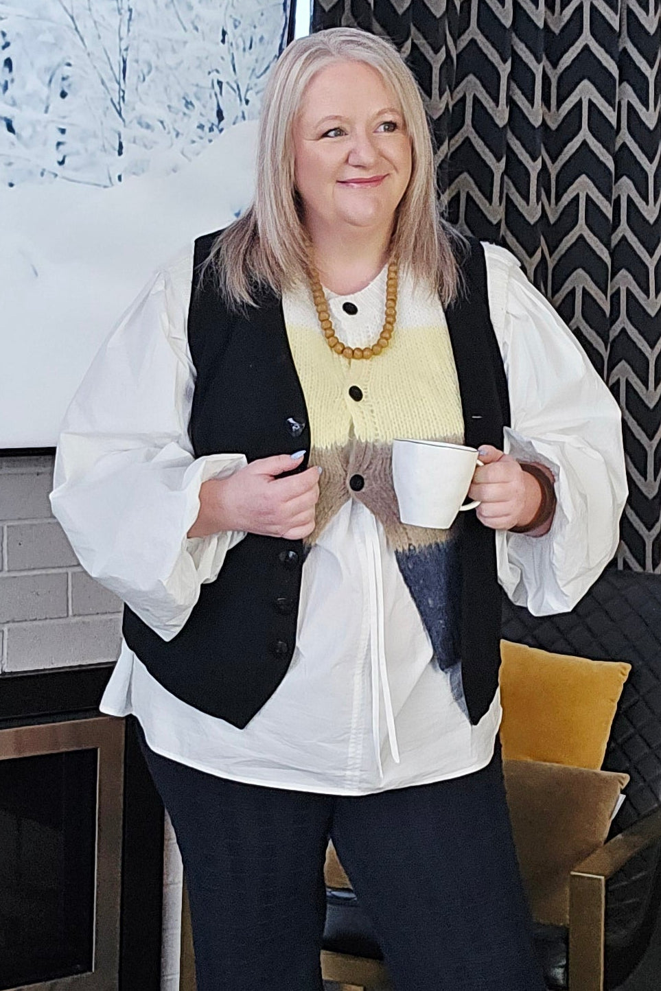 Two people standing on a patterned rug with a decorative rug and chair in the background.