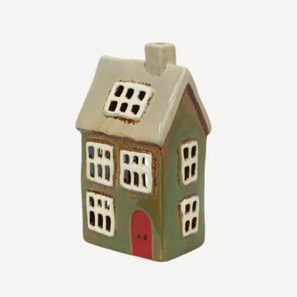 Ceramic house-shaped vase with a red door on a white background