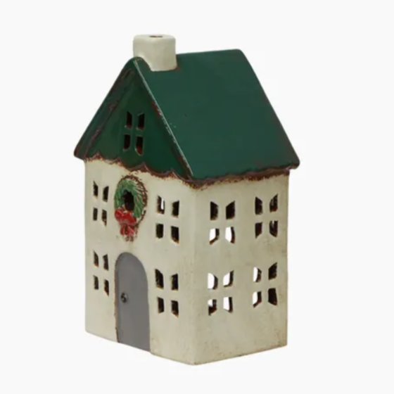 Decorative house-shaped lantern with a green roof and wreath on a white background